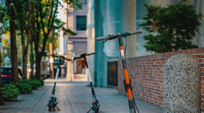 Elektryczna hulajnoga, skuter czy małe auto miejskie – który środek transportu wybrać na codzienne przejazdy Elektryczne hulajnogi zaparkowane na chodniku w centrum miasta