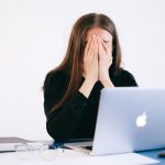 Zestresowana kobieta pracująca zdalnie przy laptopie
