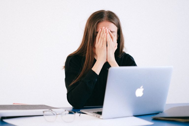 Zestresowana kobieta pracująca zdalnie przy laptopie